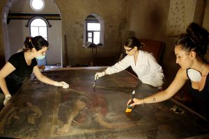 Imagen de varias restauradoras de la Fundación Tarazona Monumental, restaurando un lienzo.